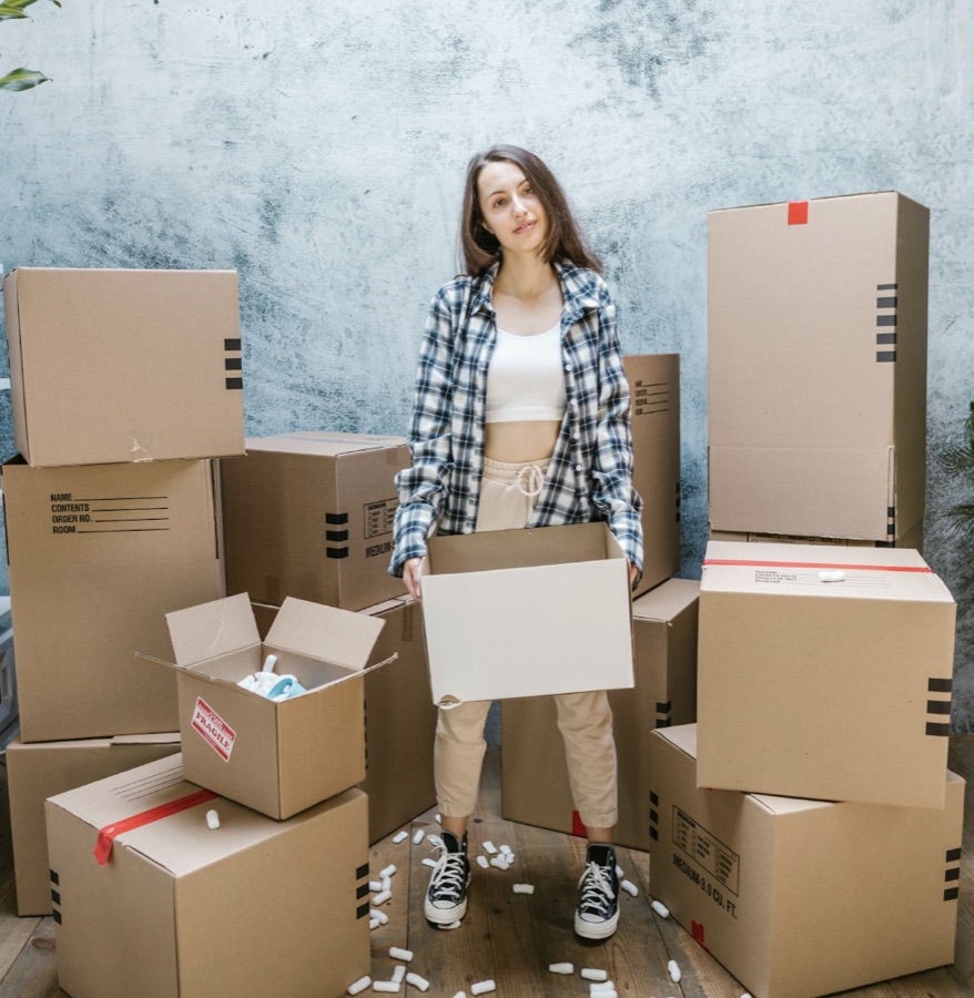 Vrouw tussen verhuisdozen, midden in een levensverandering die haar ritme beïnvloedt
